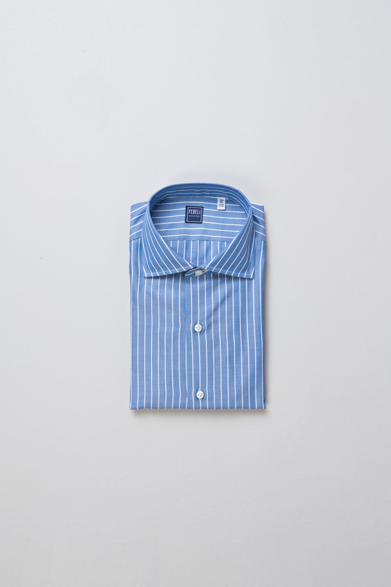 Blue and white striped shirt made from Carlo Riva fabric, showcasing meticulous craftsmanship with hand-sewn details.